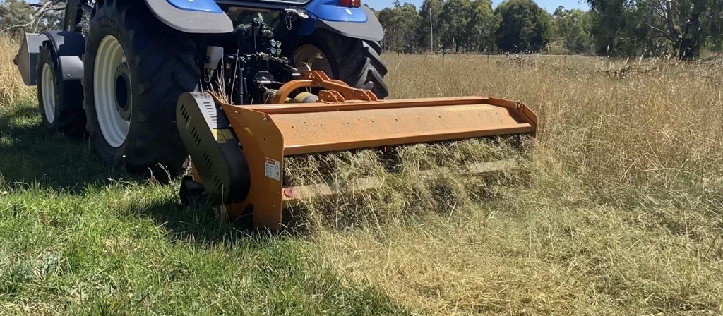 heavy machinery slashing long grass