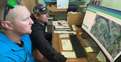 Josh Hack and George Tiedeman review the paddock data of Pasture.io in the farm office