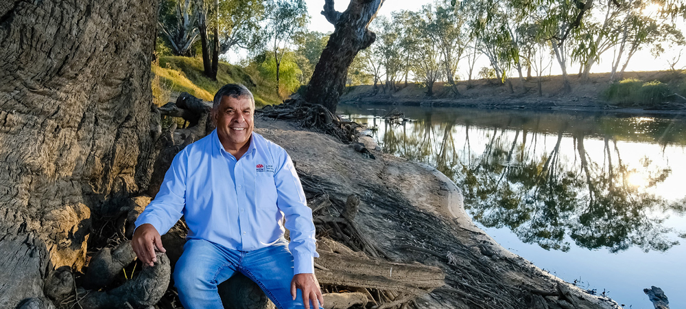 Aboriginal man sitting next to river