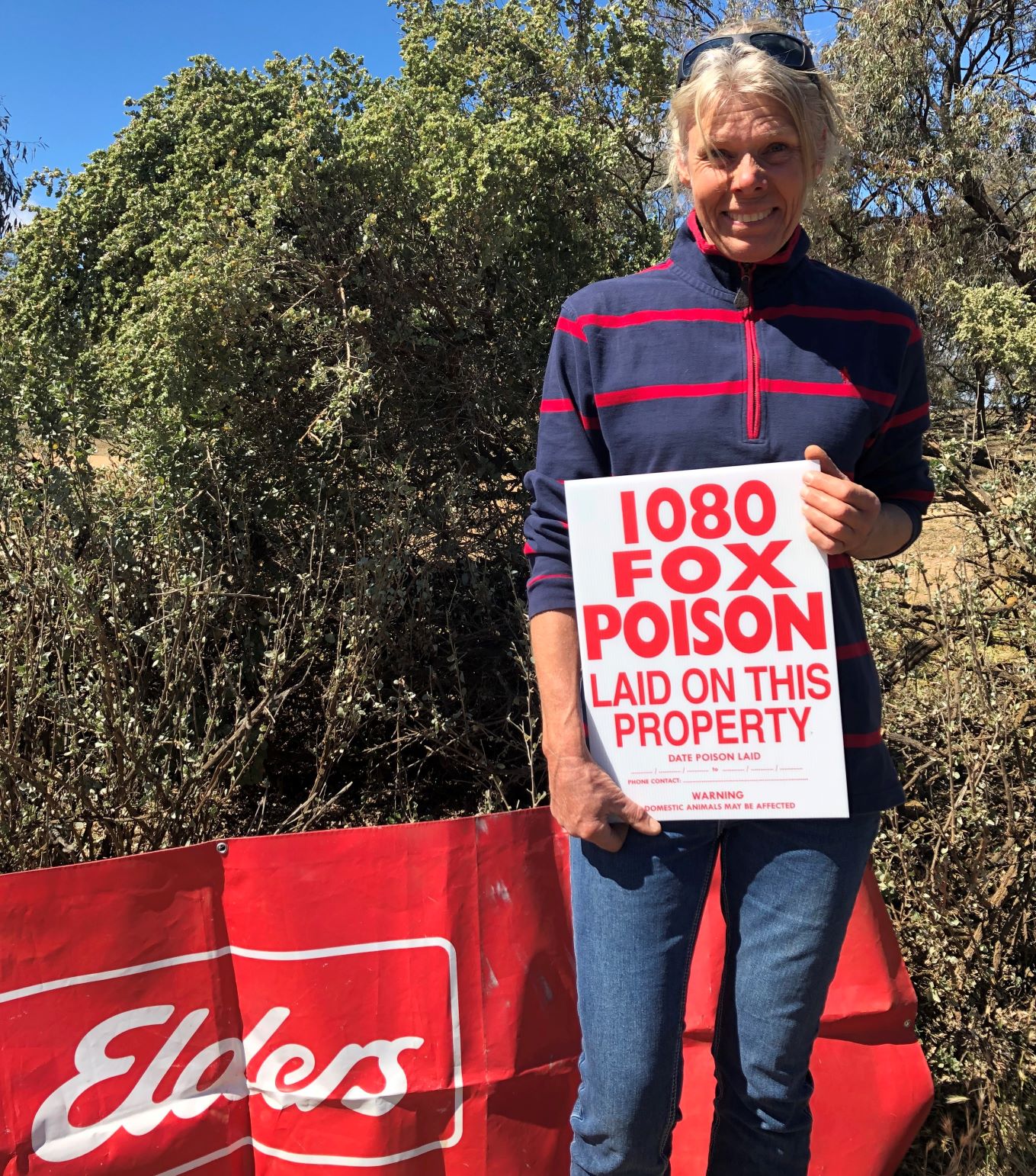Landholder Ebba Holschier on her farm with a fox baiting sign and banner from Elders, her supplier of choice for the prize.