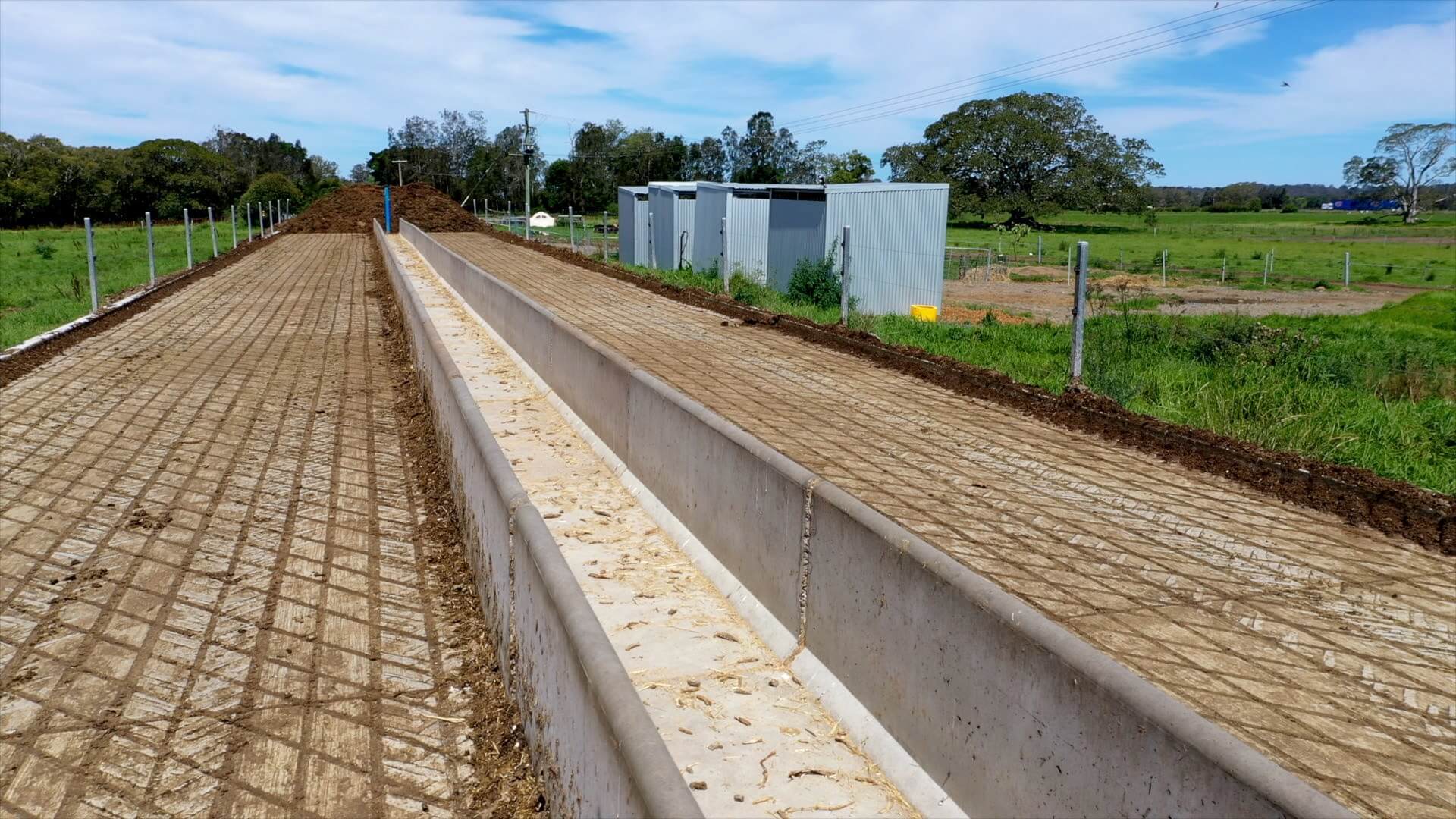 Long concrete feed pad which is separated in two parts with a feeding trough in the middle