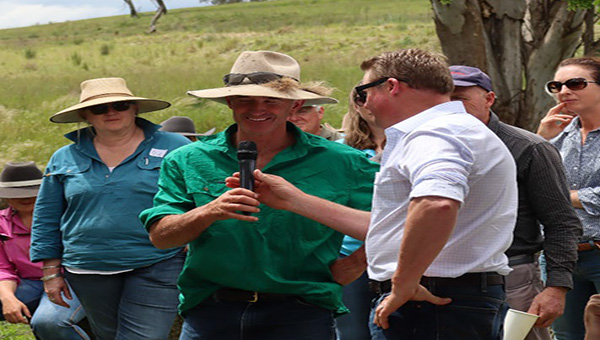 A group of farmers, one is talking into a microphone