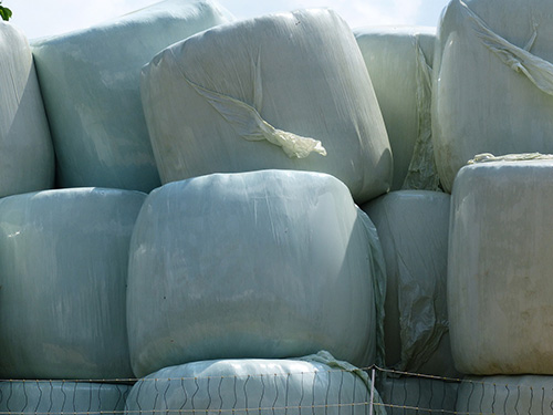 a pile of wrapped hay bales