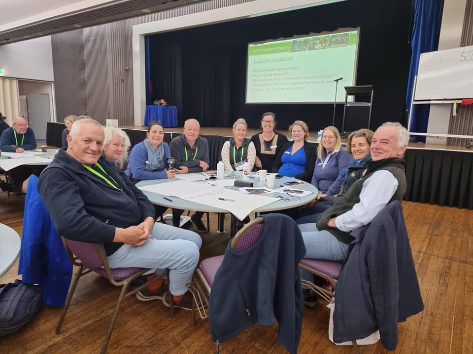 Ten people sitting around a table at a conference.