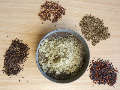 Bowl of seeds with seeds on a table surrounding.